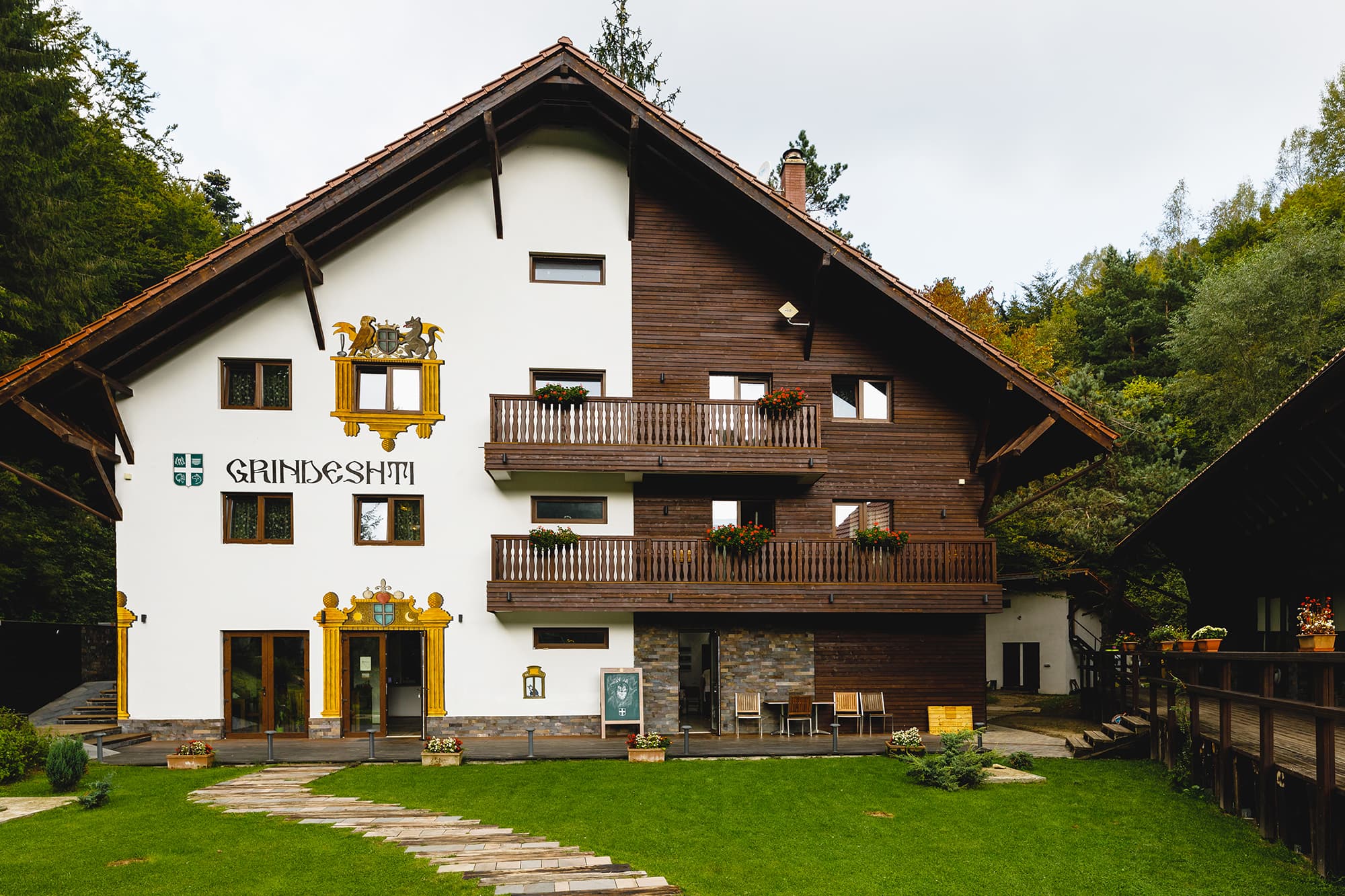 Fațada pensiunii Gasthaus Grindeshti, casă în stil tirolez cu lemn și balcoane