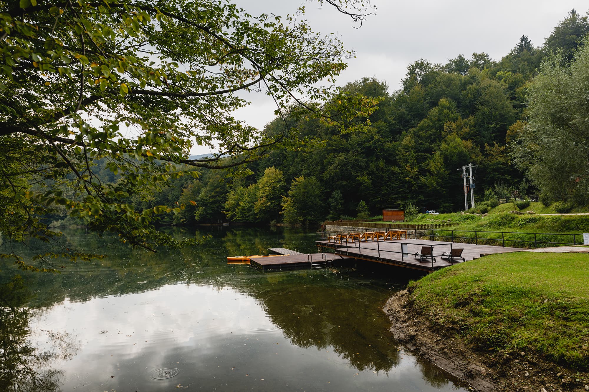 Pontonul de lemn al pensiunii pe lacul liniștit